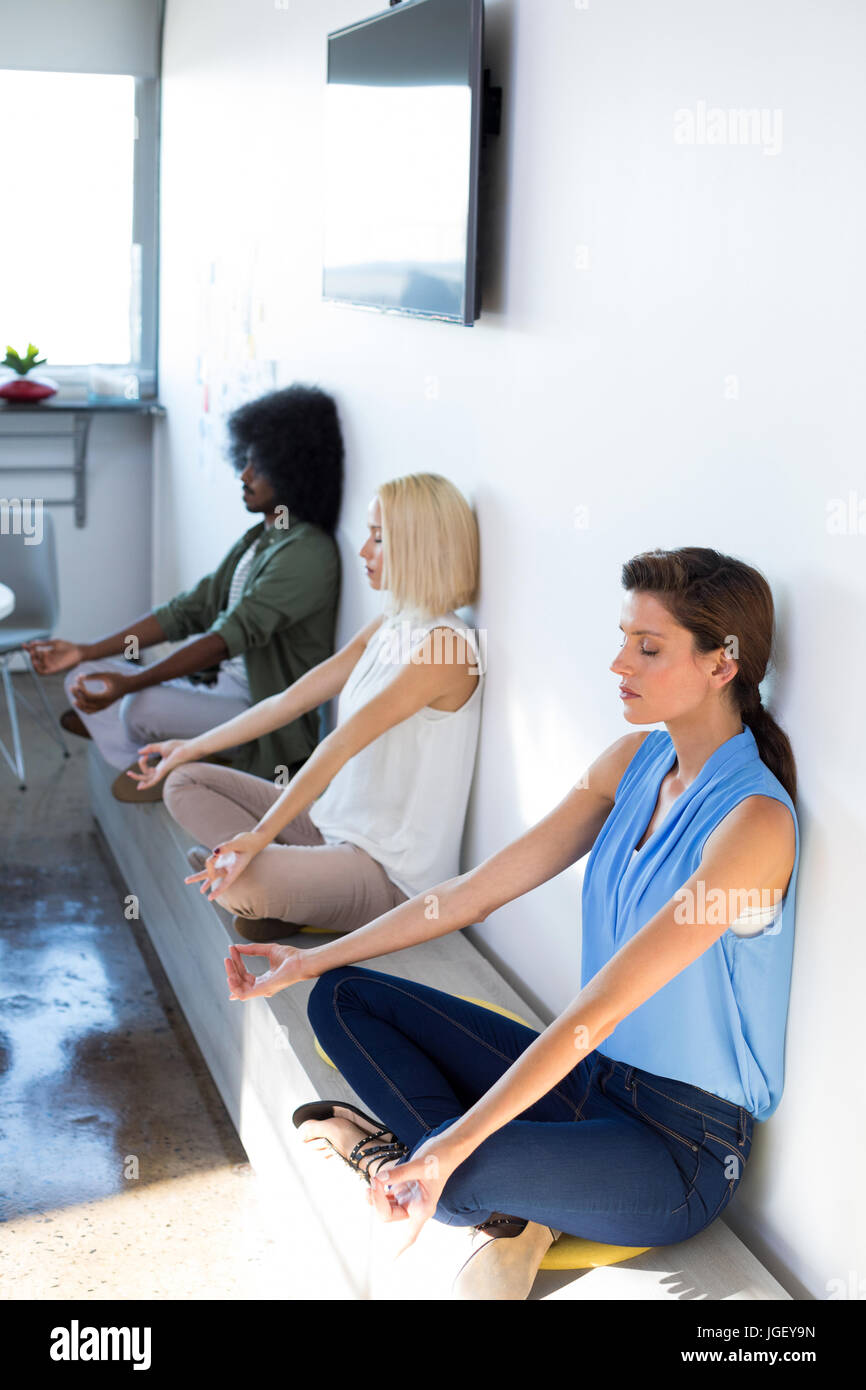 Executives doing yoga in office Stock Photo - Alamy