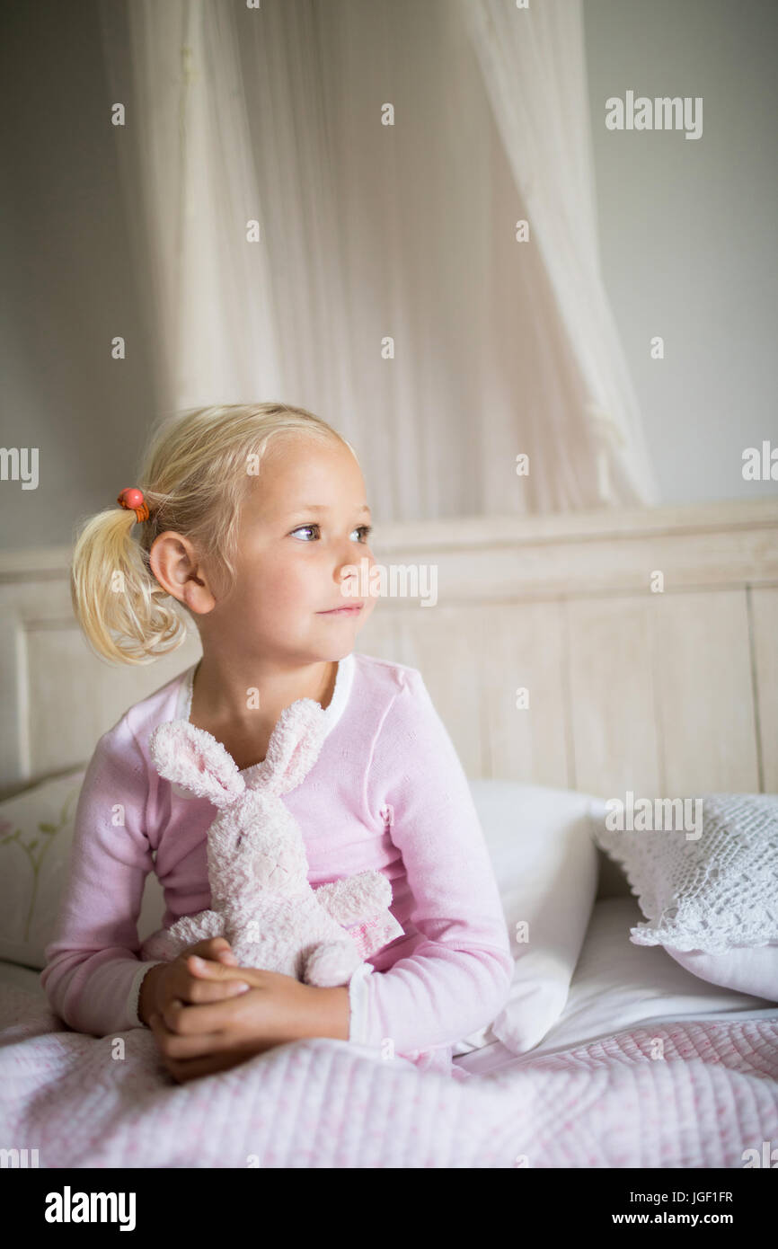 Thoughtful girl relaxing on bed in the bedroom at home Stock Photo