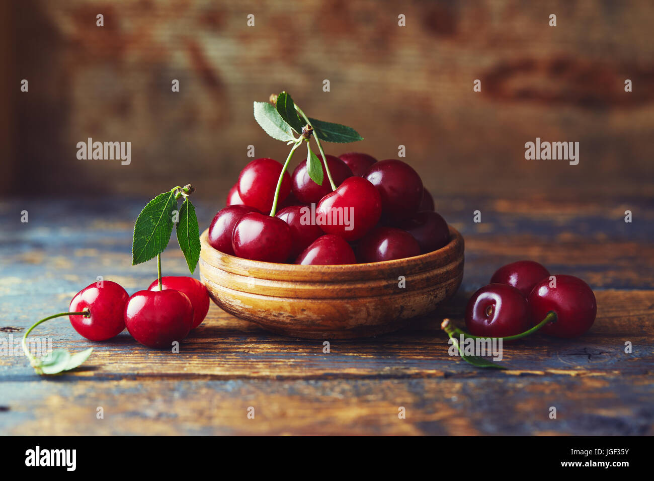 Cherries in a bowl on a wooden table. Freshly harvested cherries in a bowl on a wooden table. Stock Photo