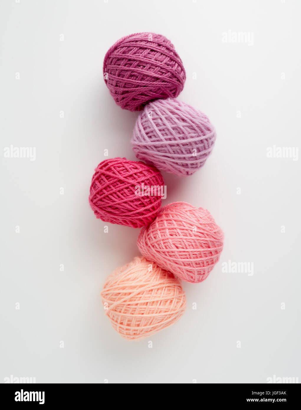Knitting yarn balls in pink tone. Colored yarn on a white background. Skeins of wool yarn for knitting. Stock Photo