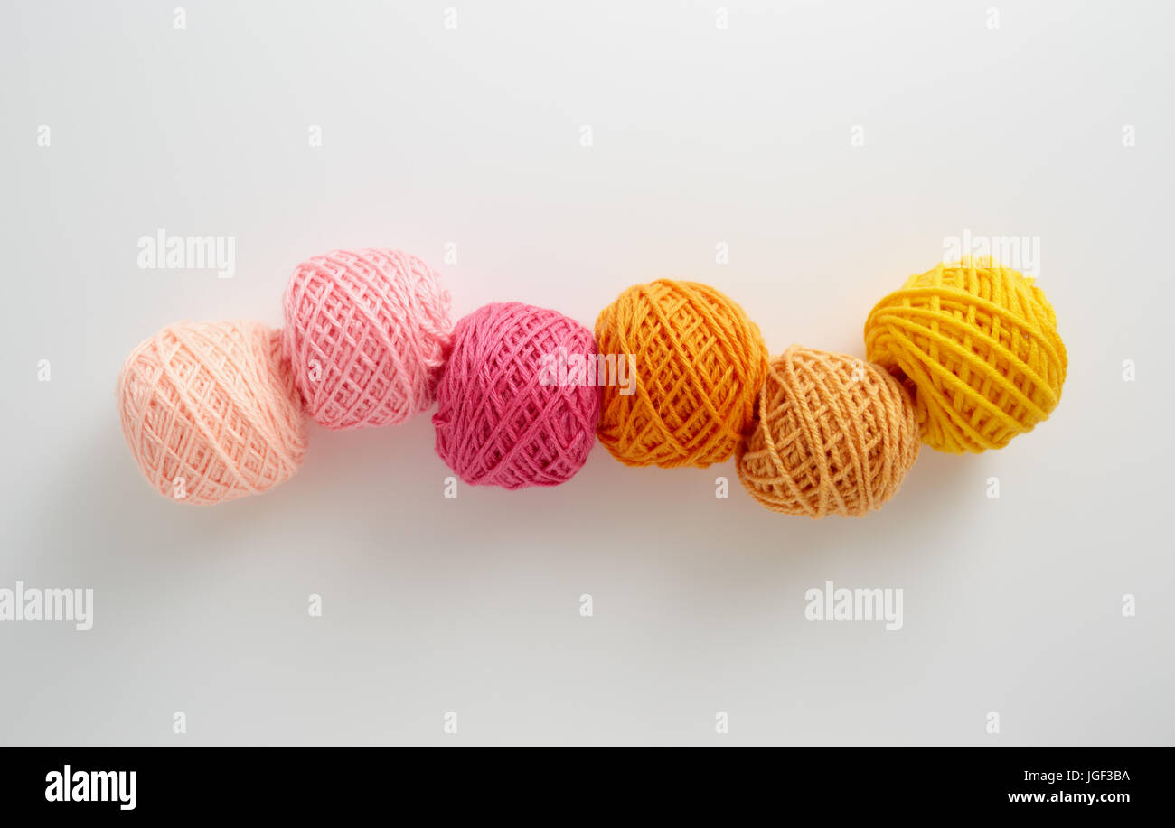 Knitting yarn balls in pink and yellow tone. Colored yarn on a white background. Skeins of wool yarn for knitting. Stock Photo
