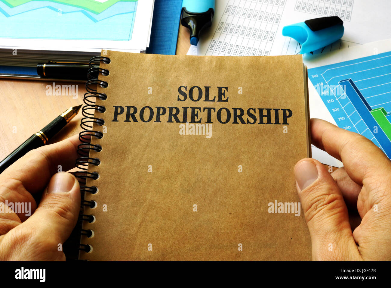 Hands holding book with title Sole proprietorship. Stock Photo