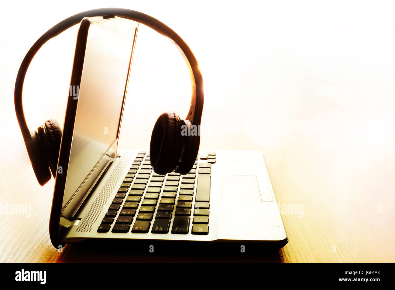Laptop and wireless headphones. Relax or outsourcing work concept. Stock Photo