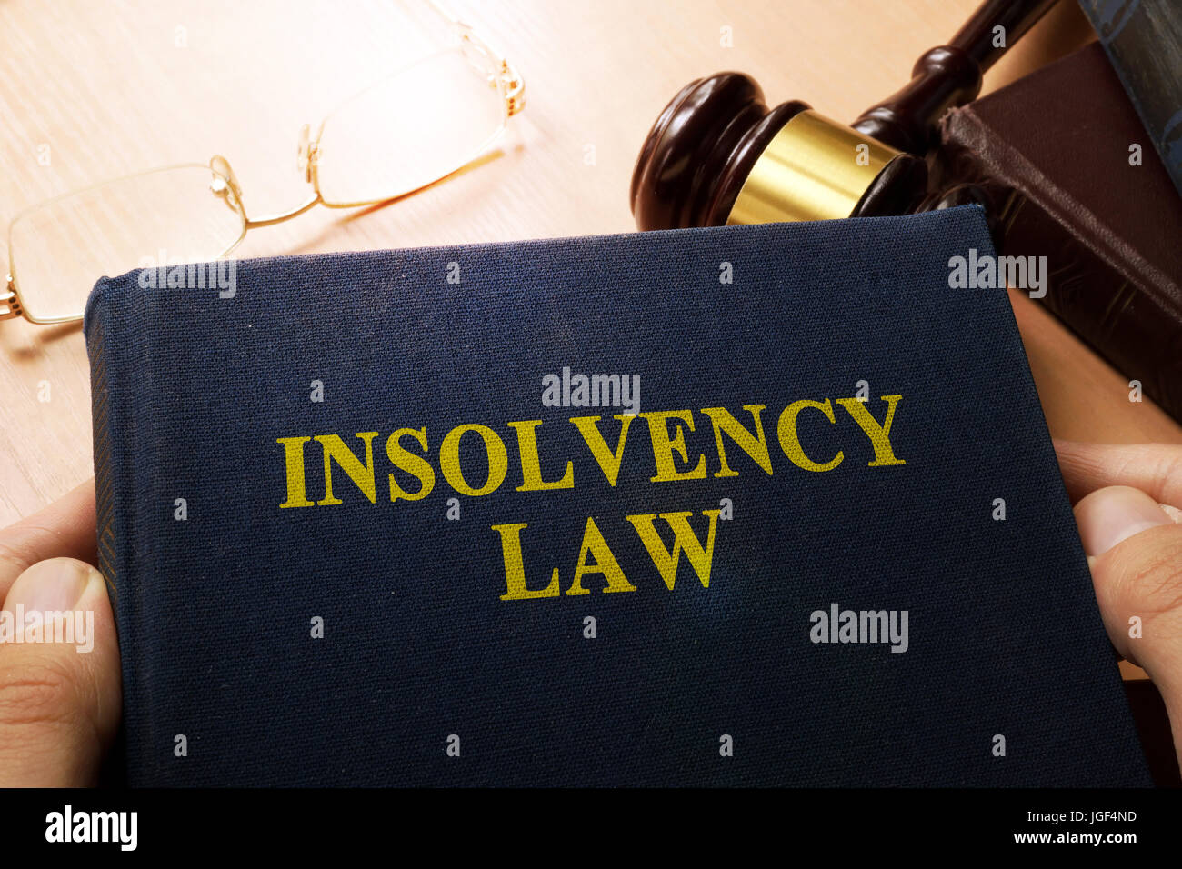 Hands holding insolvency law. Company bankruptcy concept. Stock Photo