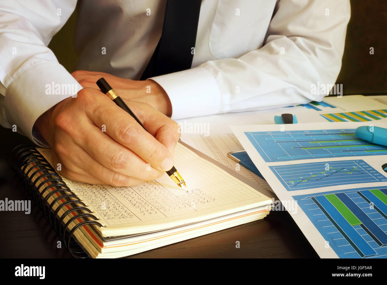 Accounting concept. Manager writing financial data into ledger book. Stock Photo