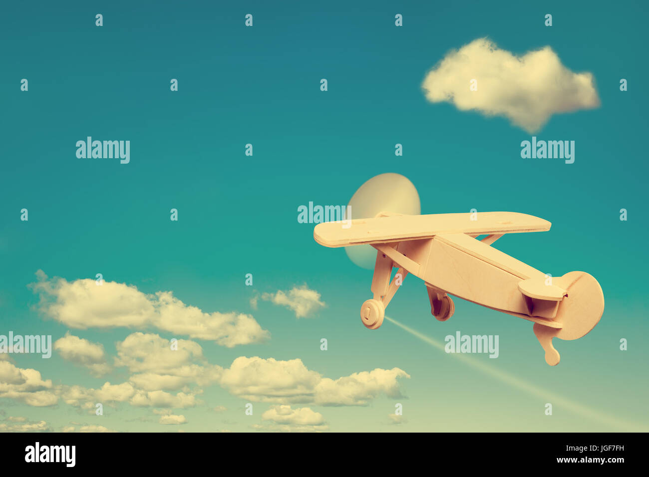 Wooden plane flying in the sky, with space for text. Stock Photo