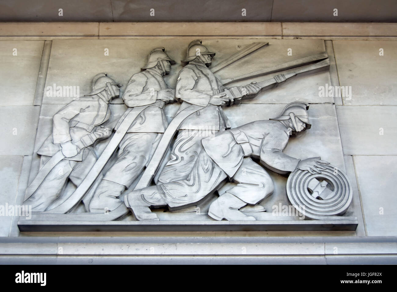 carved relief by gilbert bayes depicting firemen at work, on the exterior of the 1930s lambeth fire station, albert embankment, london, england Stock Photo