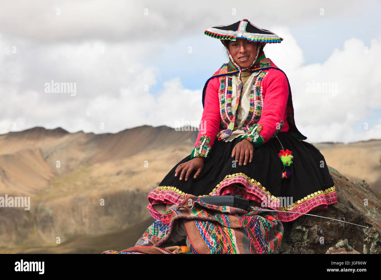 Local woman in traditional dresses at the footsteps of the Ausangate in the Andes Region of Peru. Ausangate  is a mountain of the Cordillera Vilcanota Stock Photo