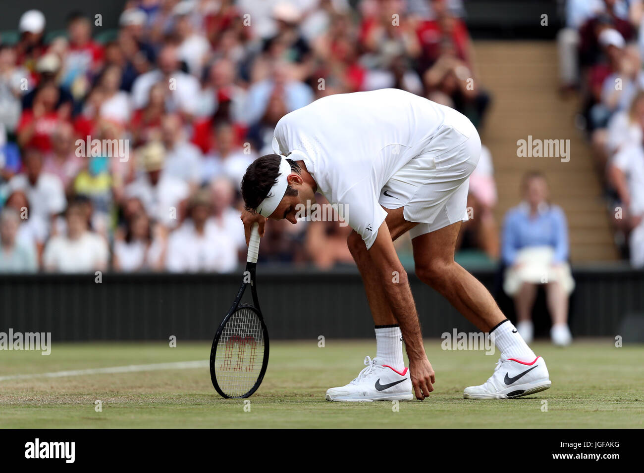 Roger Federer cleans up the centre court surface on day four of the