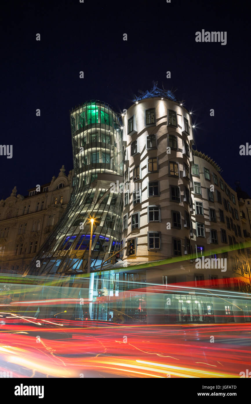 Light trails in front of the lit Dancing House building in Prague at night. The building was designed by the Croatian-Czech architect Vlado Milunic. Stock Photo