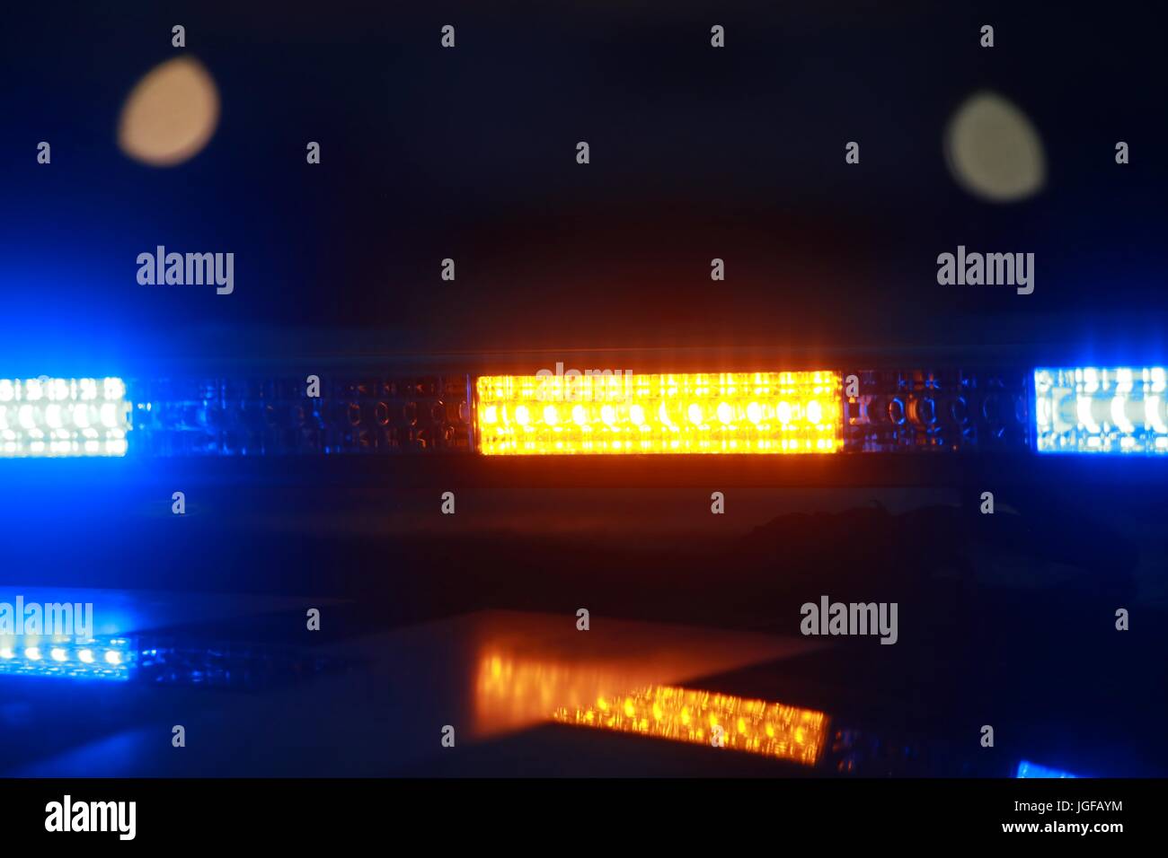Yellow and Blue Lights on Top of Police Car During Flashing at Night