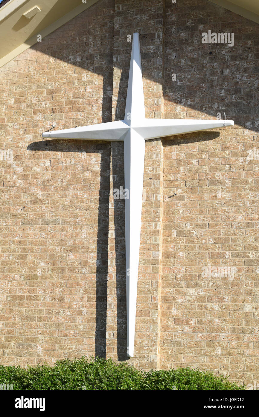 A cross hangs on the outsie wall of a church Stock Photo Alamy