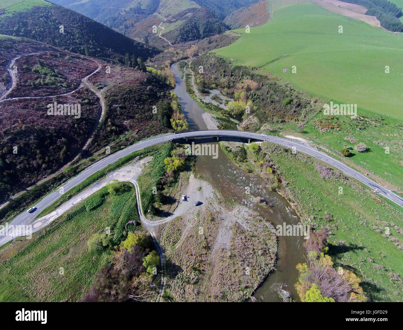 Curved bridge over Opuha River, between Geraldine and Fairlie, South Canterbury, South Island, New Zealand - drone aerial Stock Photo