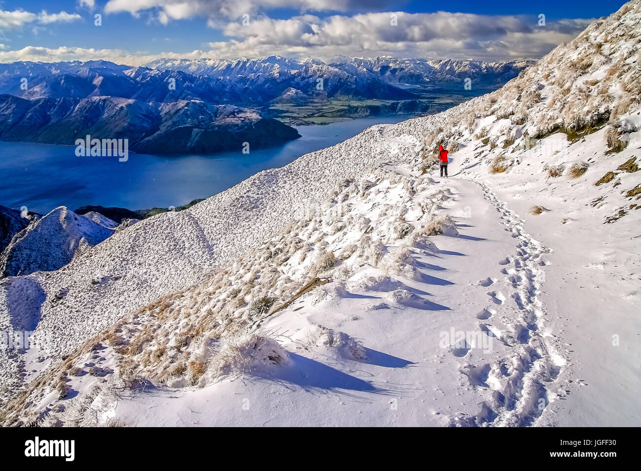 Trekker walking down the path leading up to the summit of Mount Roy, South Island, New Zealand Stock Photo