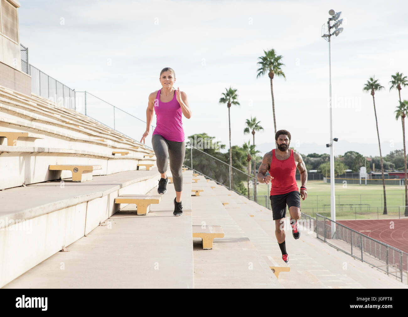 Man and woman running on bleachers Stock Photo Alamy