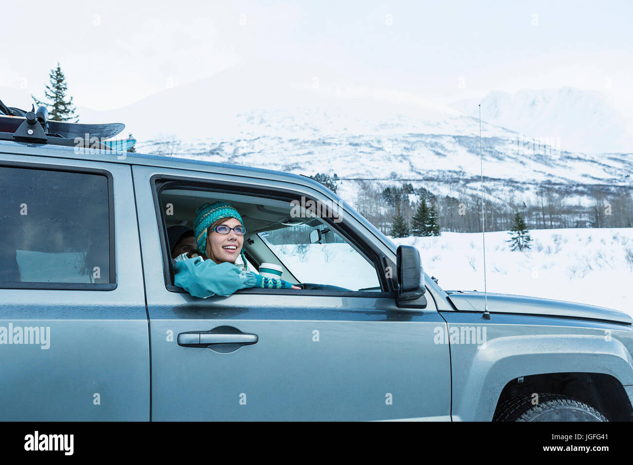 Caucasian woman  leaning in car window in winter Stock Photo