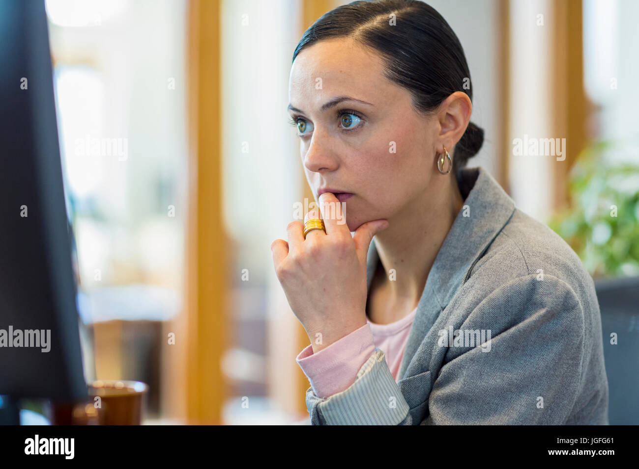 Caucasian businesswoman staring at computer in office Stock Photo