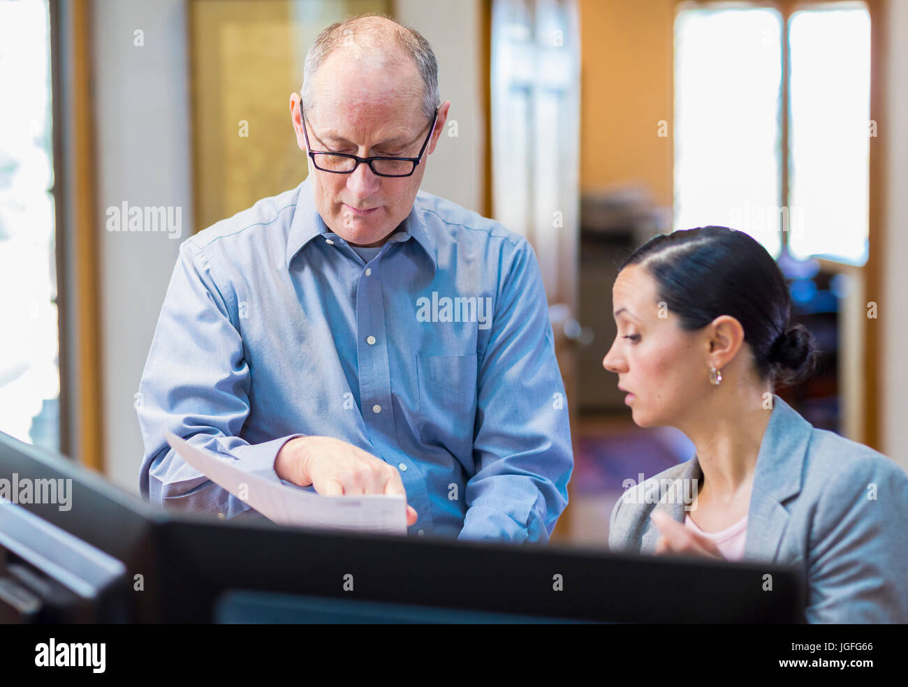 Caucasian business reading paperwork in office Stock Photo