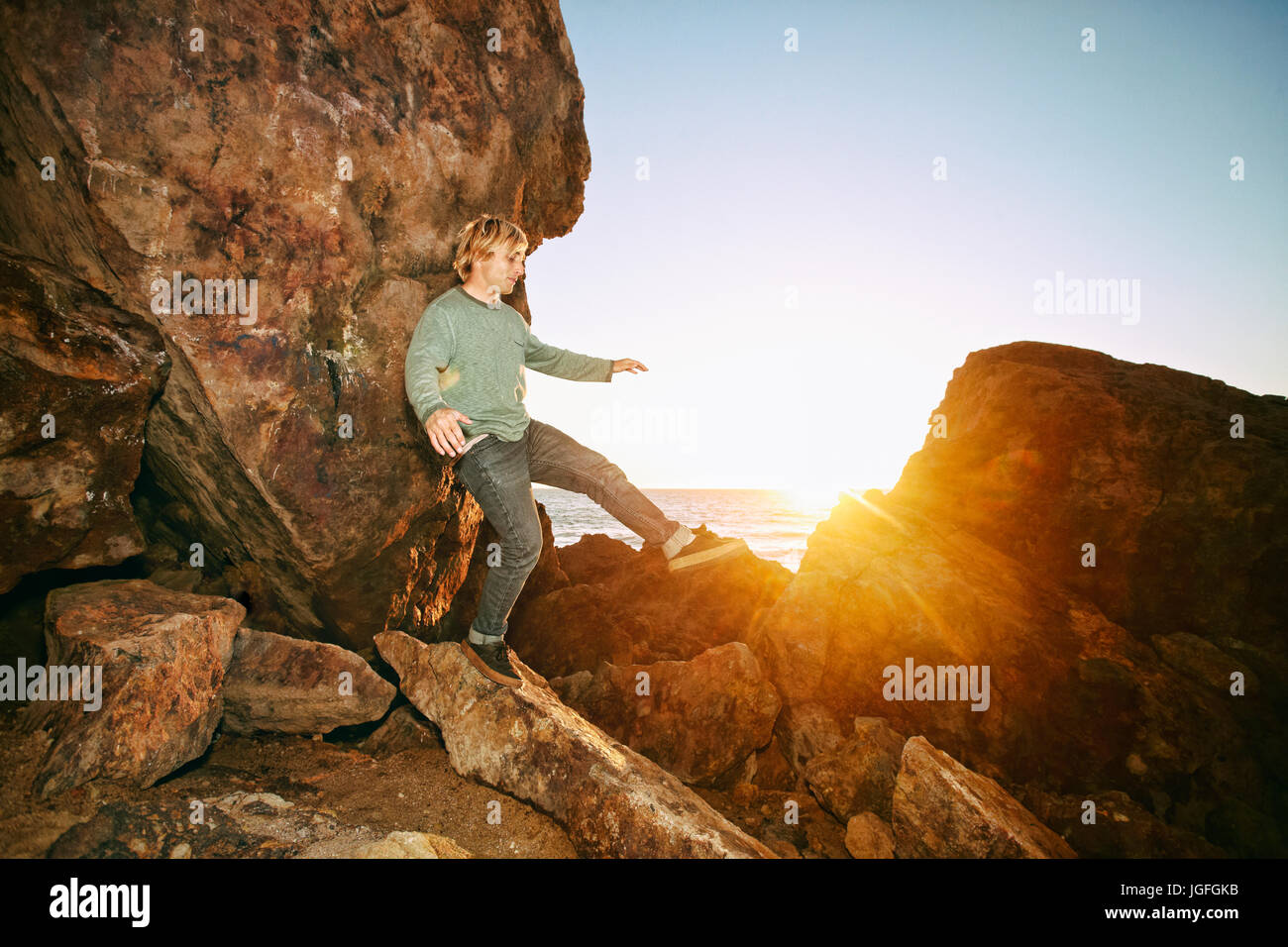 Caucasian man balancing on rocks at ocean Stock Photo - Alamy