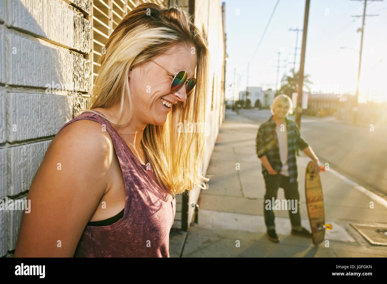 Caucasian woman laughing on sidewalk Stock Photo