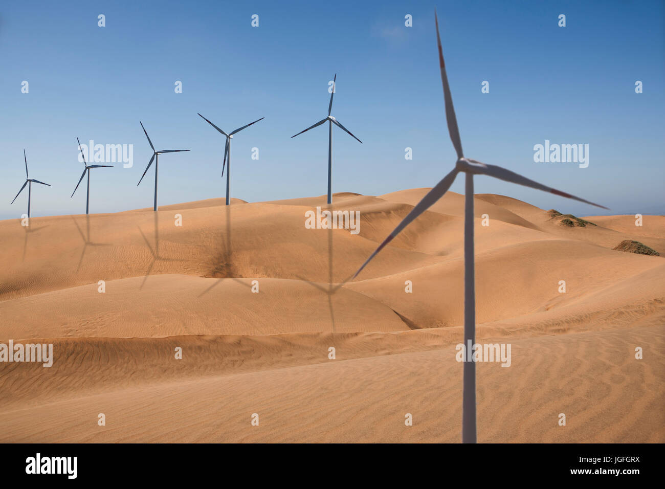 Row of wind turbines in desert Stock Photo