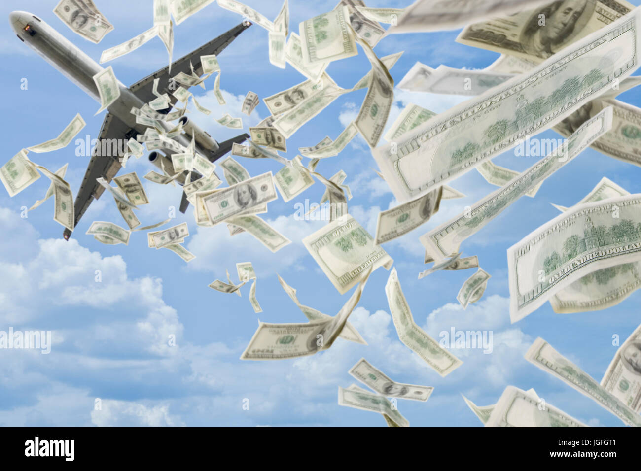 Money falling in sky under airplane Stock Photo
