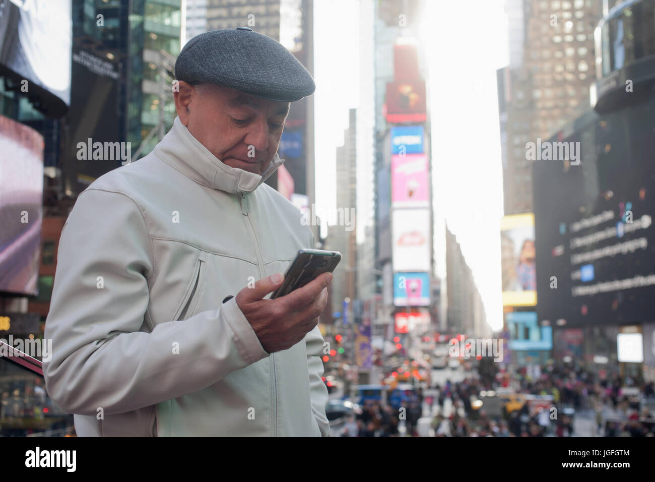 Hispanic man texting on cell phone in crowded city Stock Photo