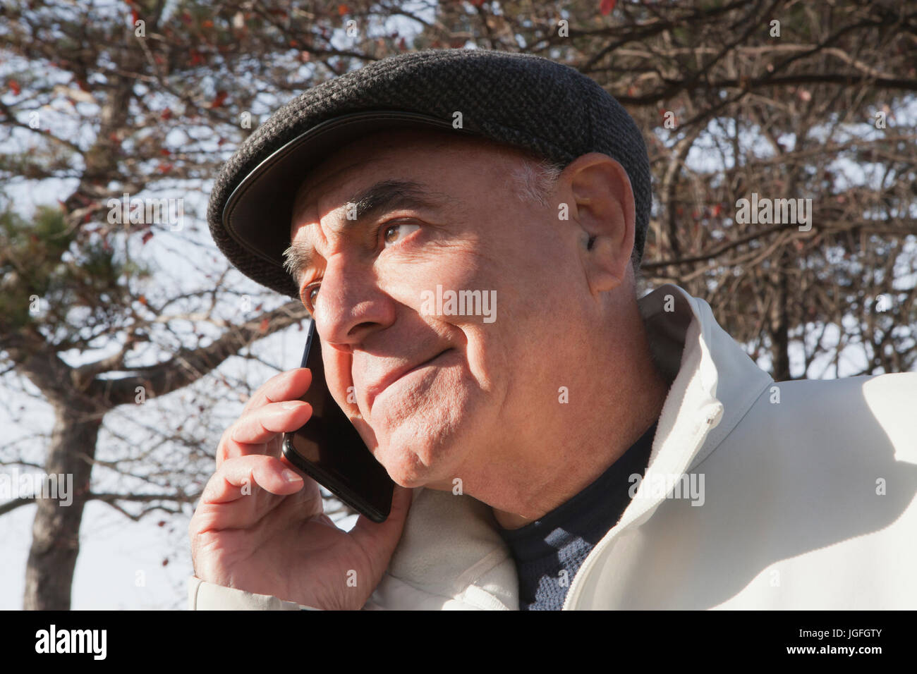 Close up of Hispanic man talking on cell phone Stock Photo