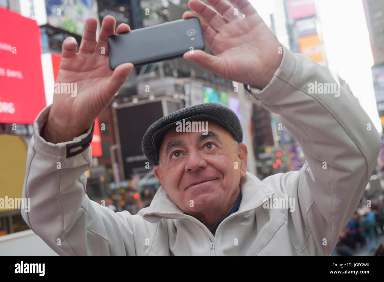 Hispanic man posing for cell phone selfie in city Stock Photo