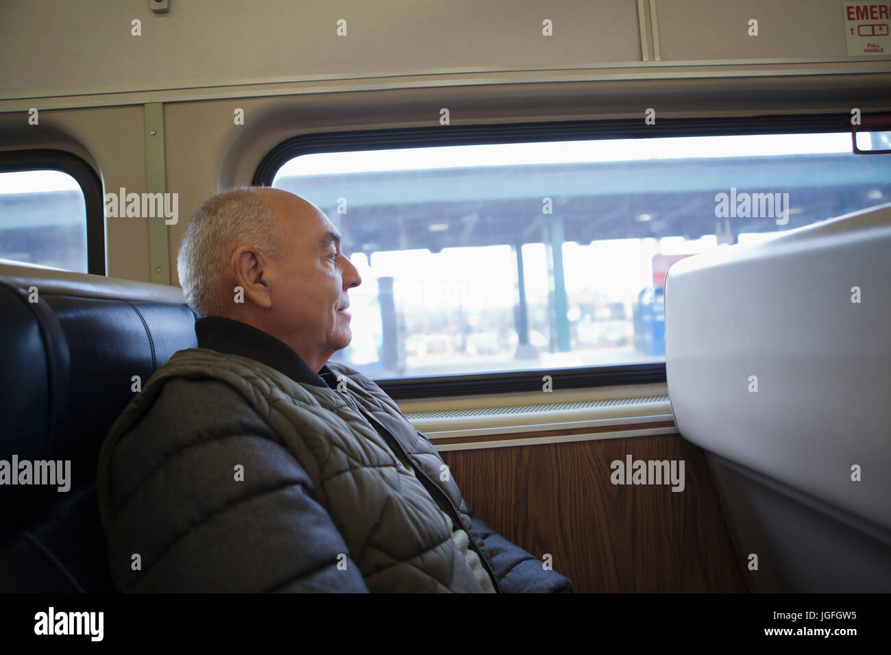 Hispanic man sitting on train Stock Photo
