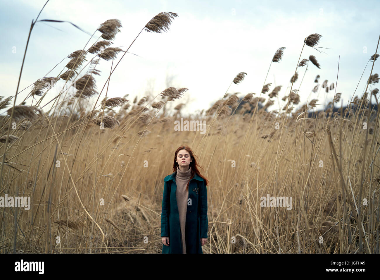 Caucasian woman standing in field with eyes closed Stock Photo - Alamy
