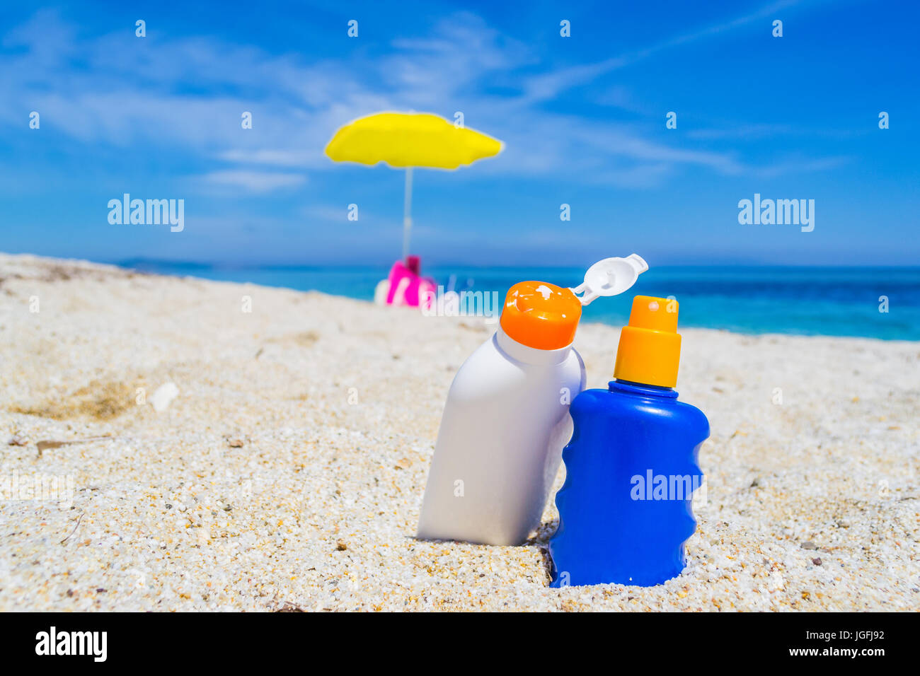 suntan lotion bottles on the sand Stock Photo