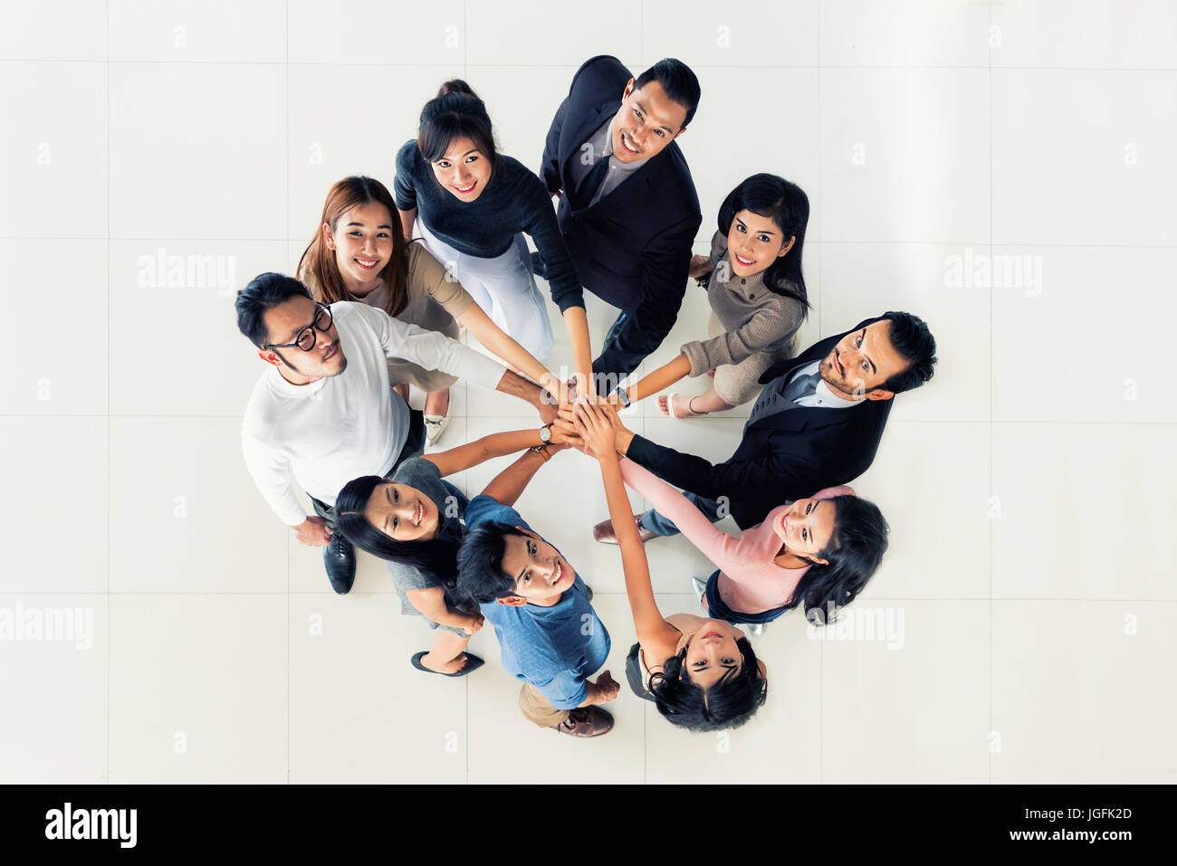 Top view of Group of multi-ethnic business partners putting hands together. Concept of business teamwork and success. Stock Photo