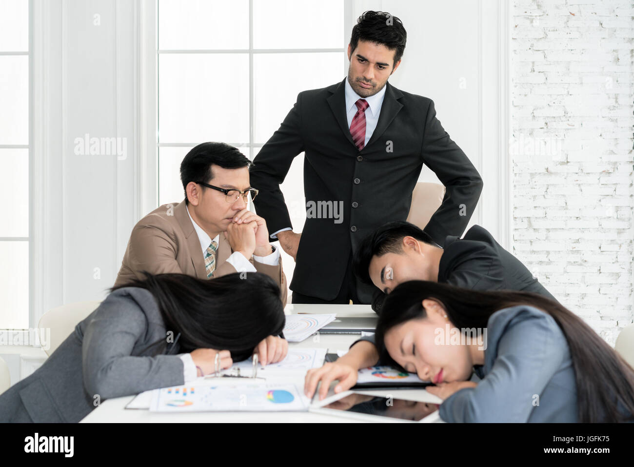 Boss angry when business people team sleeping on meeting room in office. Business people team tired after working hard. Stock Photo