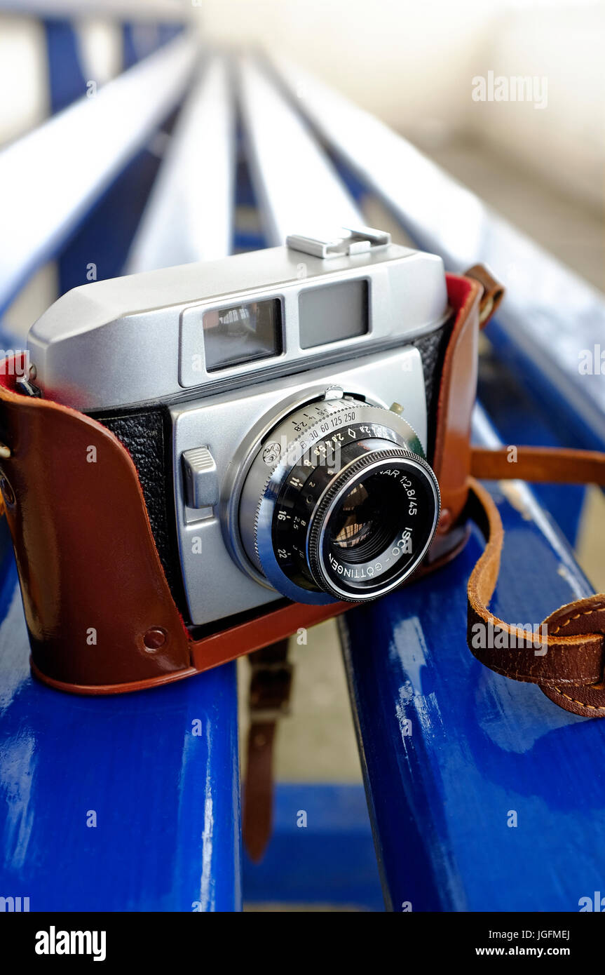 old retro style 35mm rangefinder camera on blue painted bench Stock Photo