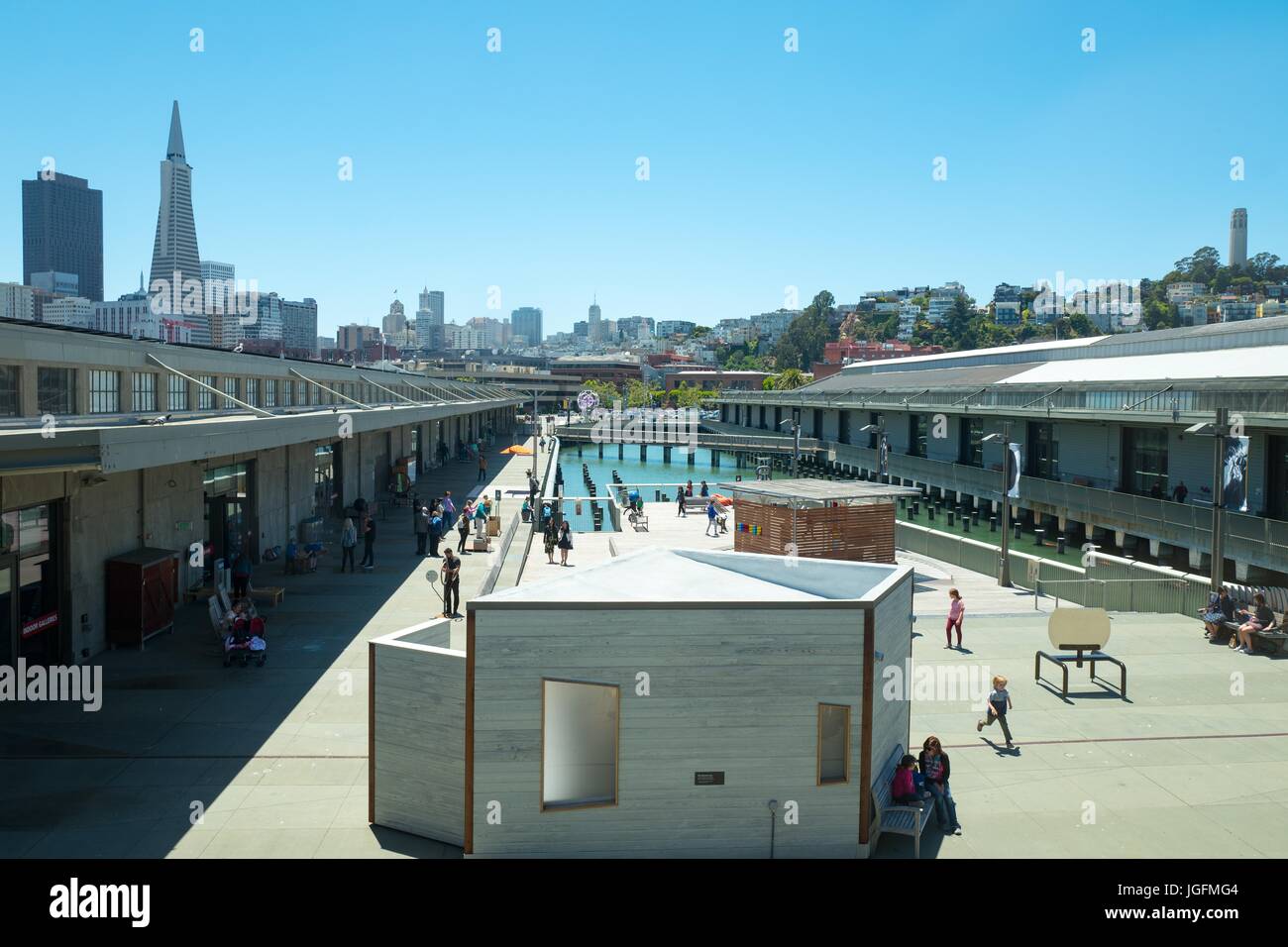 Both Coit Tower and the Transamerica Pyramid Building, two major landmarks, are visible above buildings for the Exploratorium science museum on the Embarcadero in downtown San Francisco, California, June 13, 2017. Stock Photo