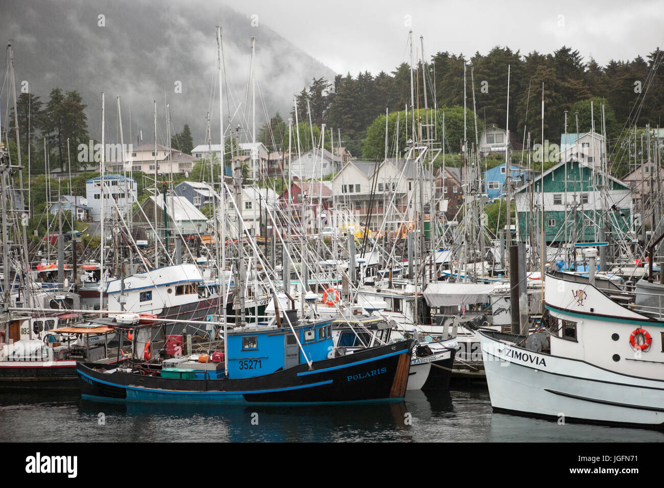 Many boats fill a marina and harbor near houses locataed in downtown Sitka, Alaska. Stock Photo