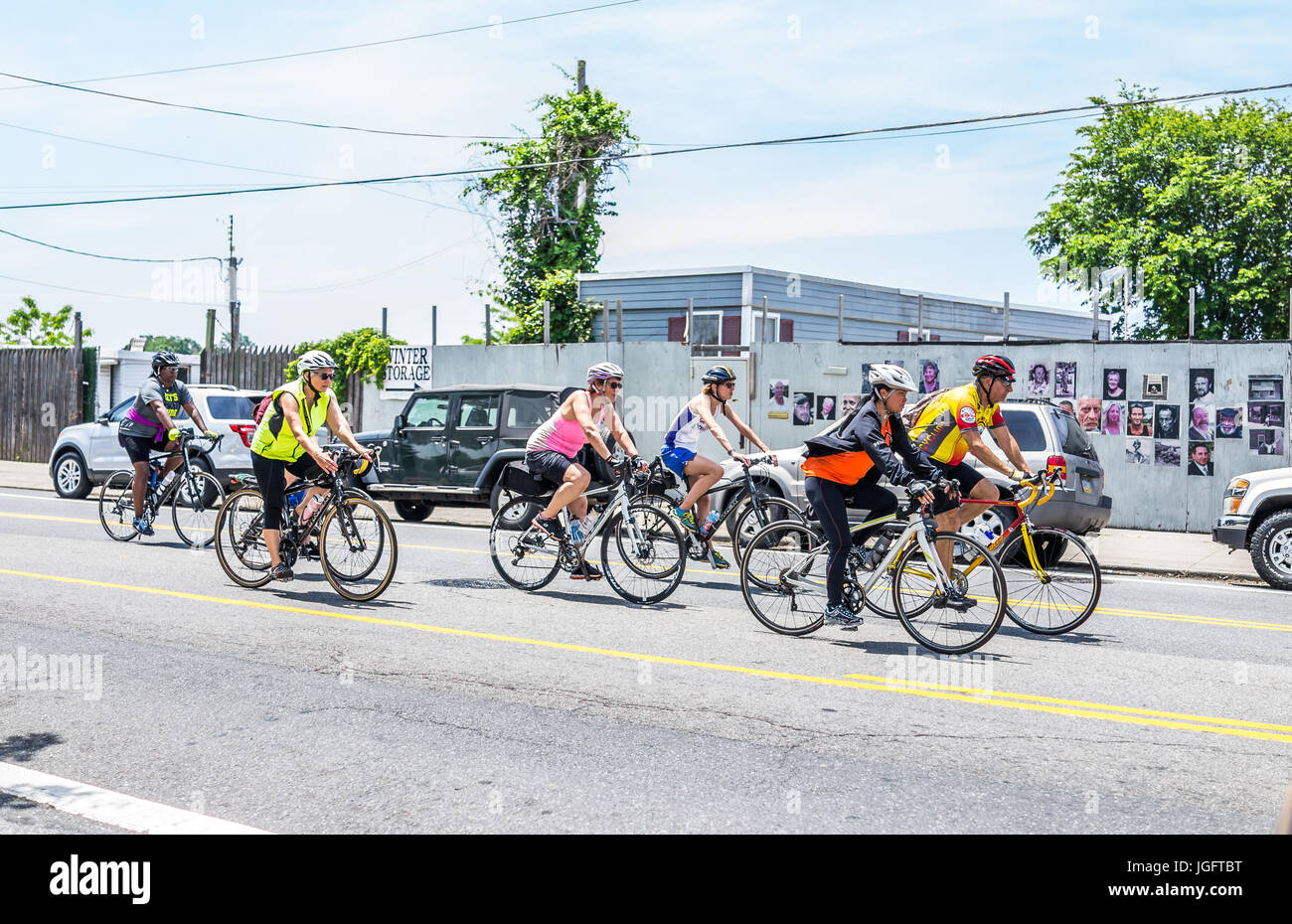 Bronx, USA - June 11, 2017: People riding bicycles in weekend marathon race on outside street or road in City Island by harbor Stock Photo