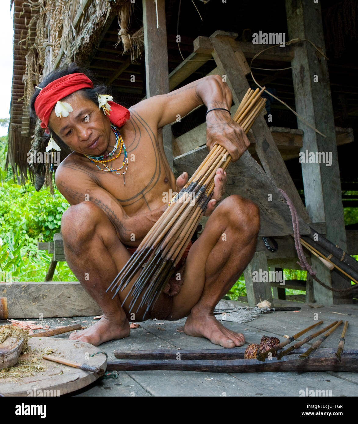 MENTAWAI PEOPLE, WEST SUMATRA, SIBERUT ISLAND, INDONESIA – 16 NOVEMBER 2010: Men Mentawai tribe prepare arrows for hunting. Stock Photo