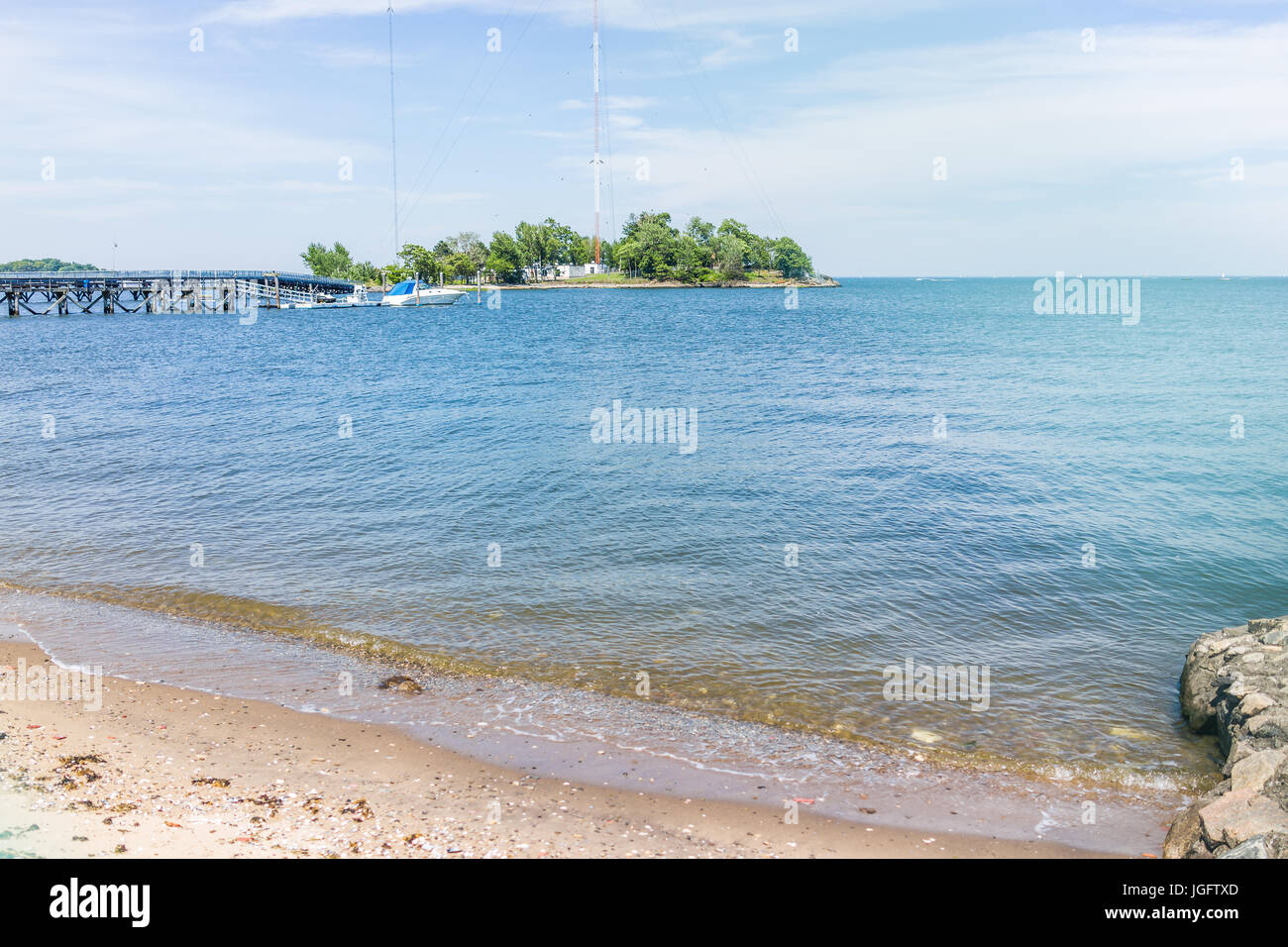 Bronx, USA - June 11, 2017: City Island harbor with boat on pier and sandy beach with ocean Stock Photo