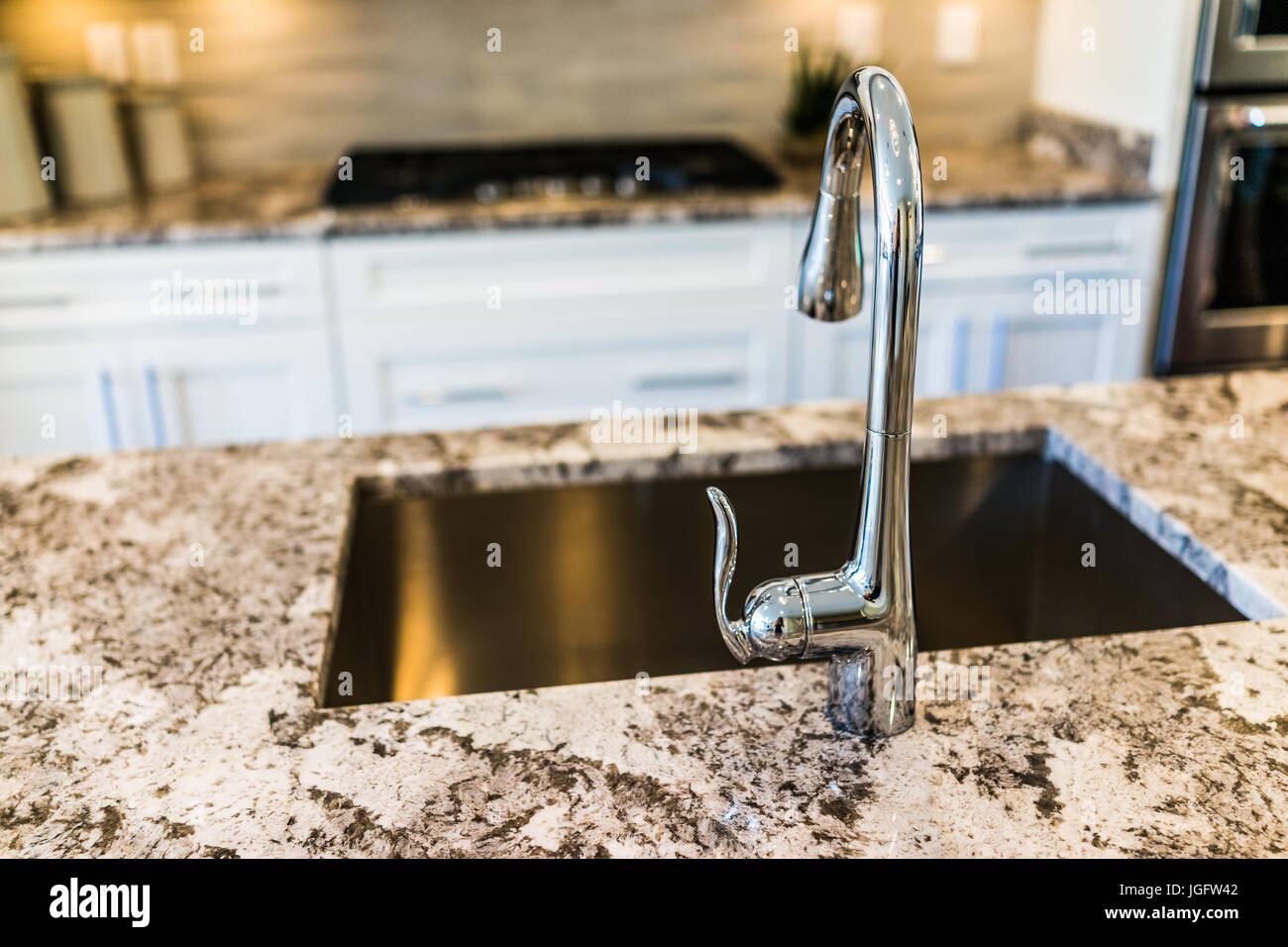 New Modern Faucet And Kitchen Sink Closeup With Island And Granite
