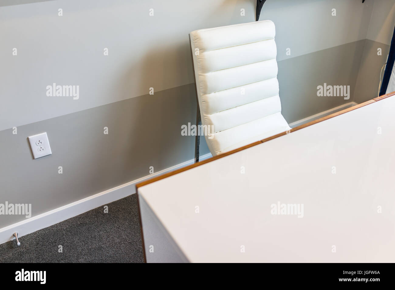 Closeup of modern white chair and desk in office in room of house Stock