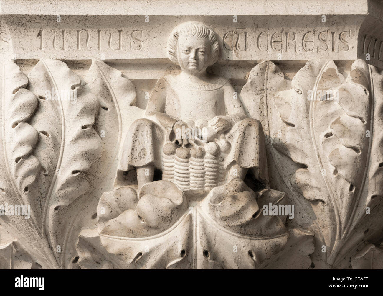 Peasant with cherries basket symbolizes the month of June, ancient medieval, relief on Venice Doge Palace column Stock Photo