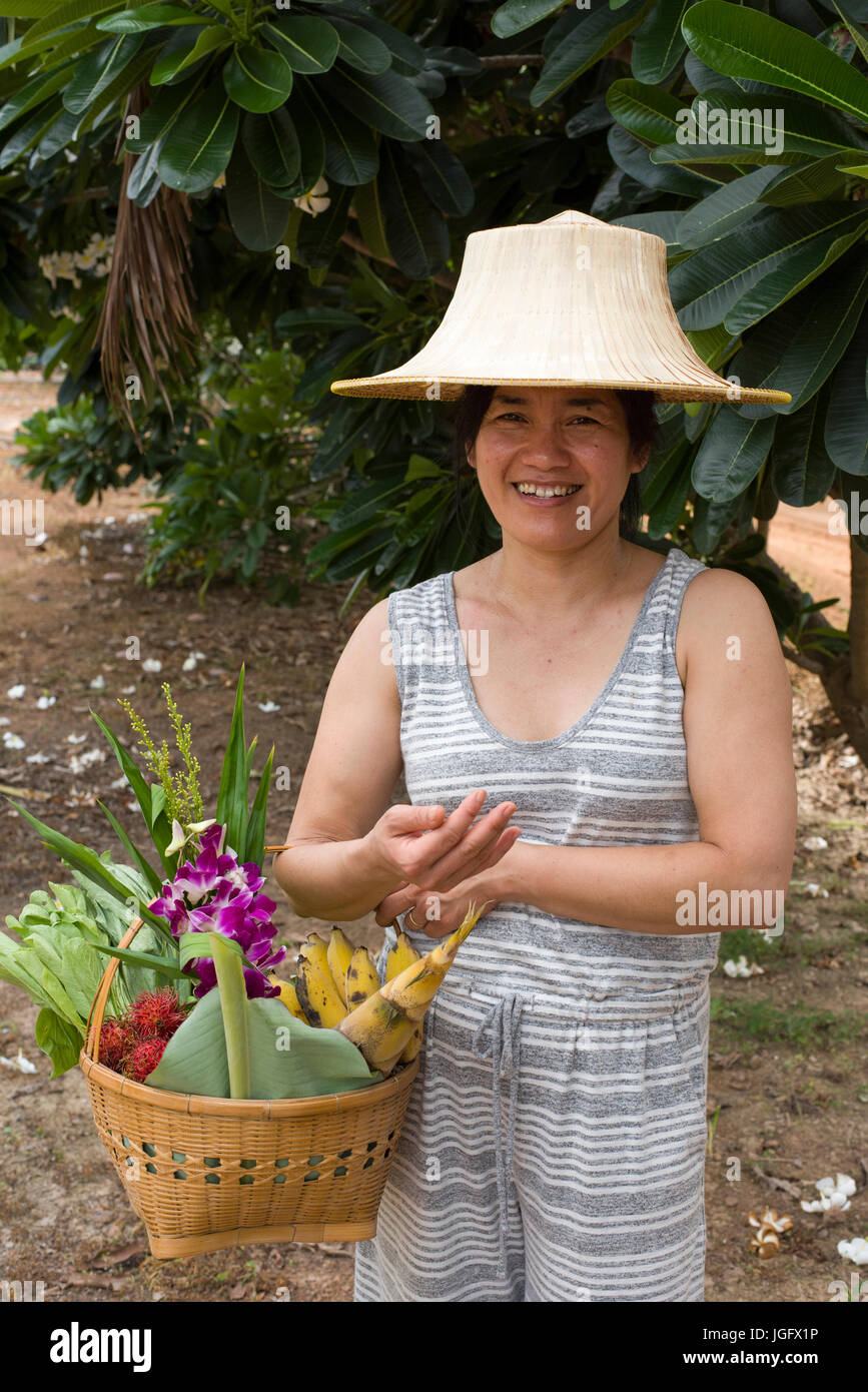 Woman carrying basket of fresh fruit and flowers Stock Photo - Alamy