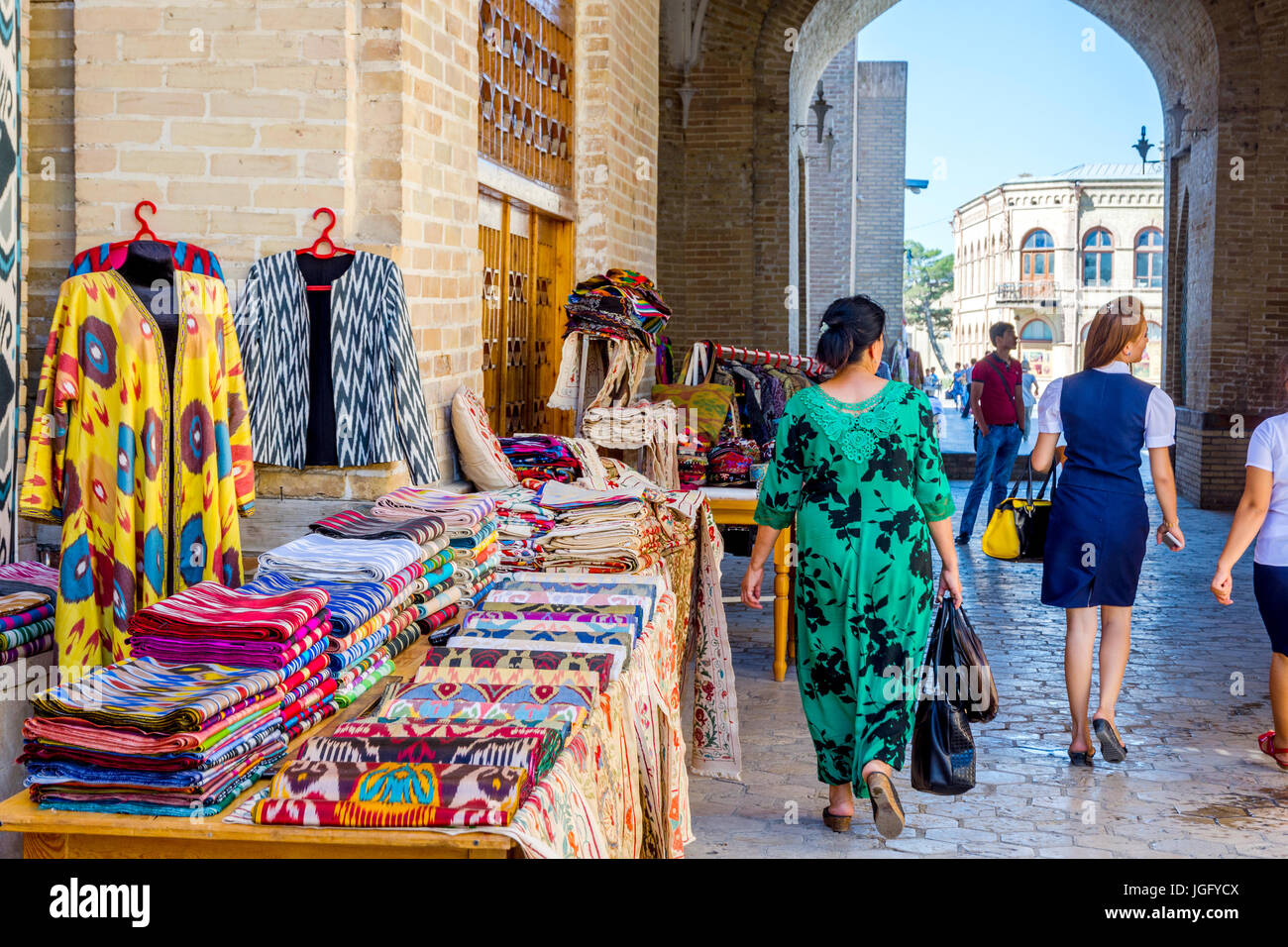 BUKHARA, UZBEKISTAN - SEPTEMBER 4: Street bazaar with souvenirs and traditional uzbek clothes in Bukhara downtown. September 2016 Stock Photo