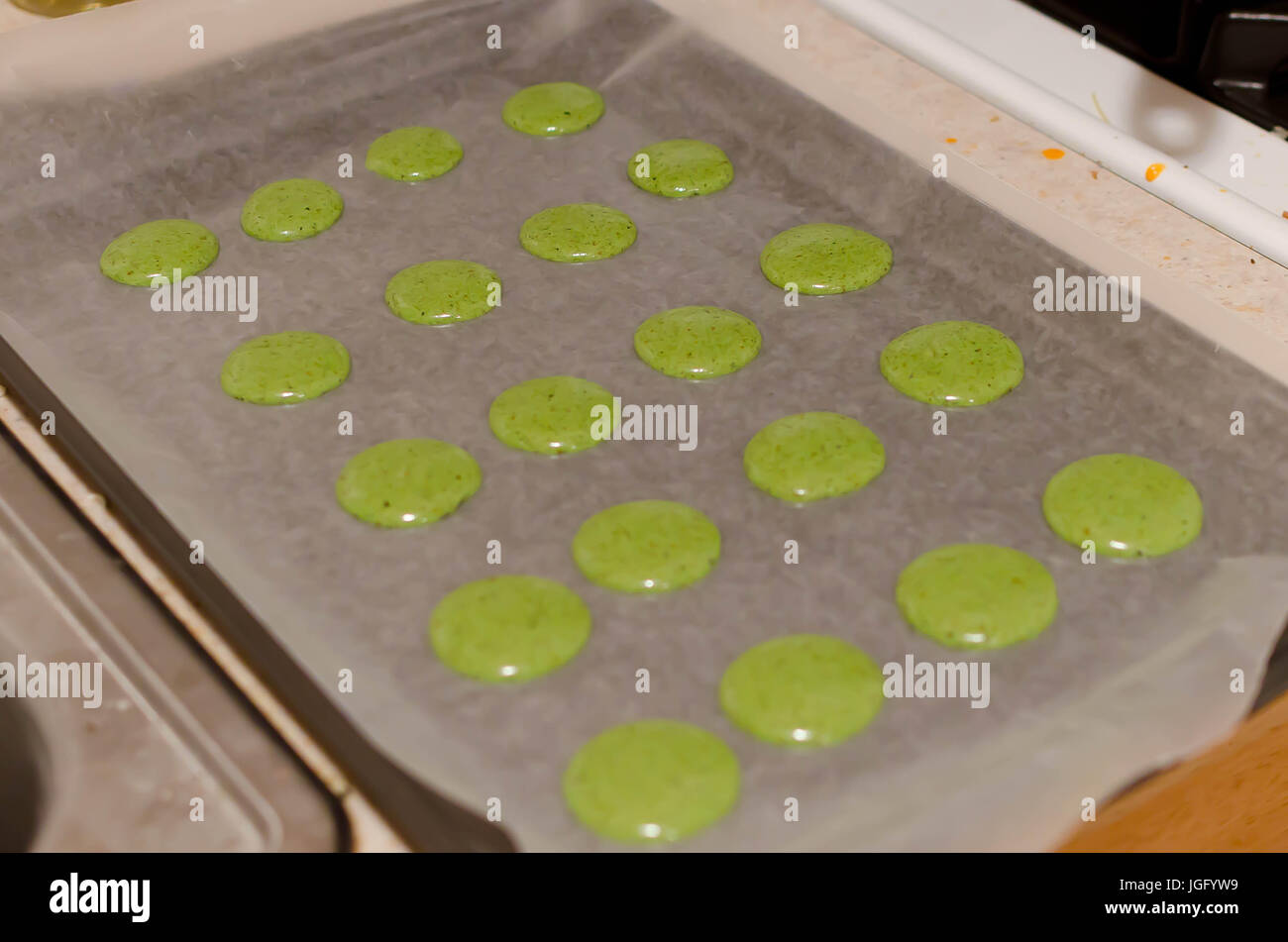 Plate of matcha macaron shells about to be baked. Stock Photo