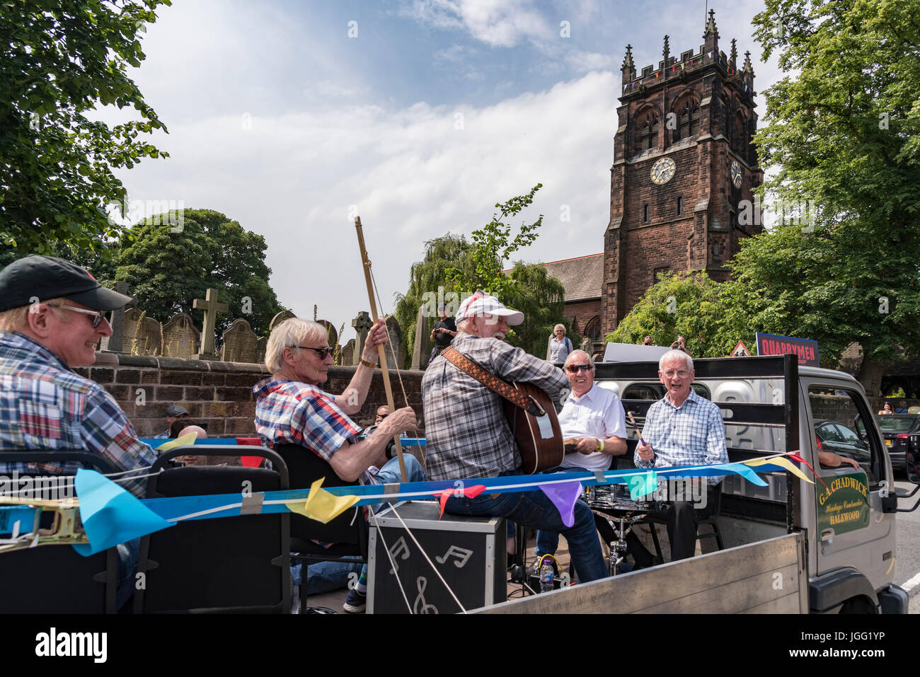 Woolton, Liverpool, UK. 6th July 2017. A parade was held in Woolton Liverpool today to mark the day 60 years ago at the St. Peter's church fete that brought John Lennon and Paul McCartney together to form the Beatles. John Lennon's original band The Quarrymen took a ride round the village on a local lorry and today surviving members of the group recreated the drive with original lorry driver Dougie Chadwick at the wheel. Credit: John Davidson/Alamy Live News Stock Photo