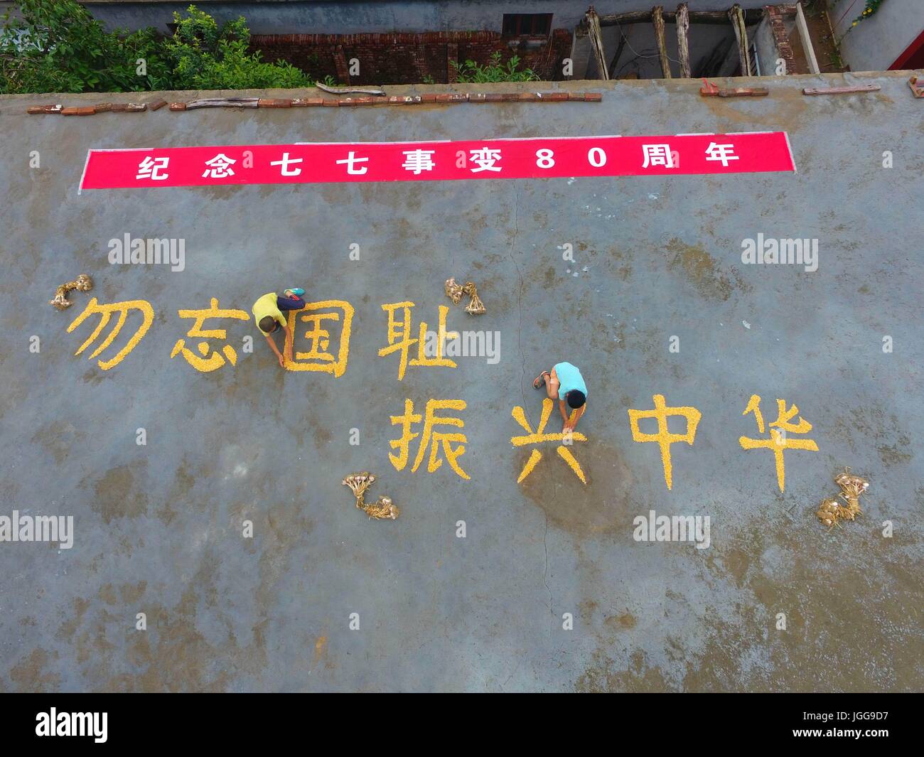 Liaocheng, Liaocheng, China. 6th July, 2017. Liaocheng, CHINA-July 6 2017: (EDITORIAL USE ONLY. CHINA OUT) Villagers and volunteers form eight Chinese characters saying 'Never Forget History, Reinvigorate the Country' with corns in Liaocheng, east China's Shandong Province, July 6th, 2017, marking the 80th anniversary of the July 7th 1937 Incident. July 7 marks the 80th anniversary of the Marco Polo Bridge Incident, which triggered the Chinese People's War of Resistance Against Japanese Aggression (1937-45) across the country. Credit: SIPA Asia/ZUMA Wire/Alamy Live News Stock Photo