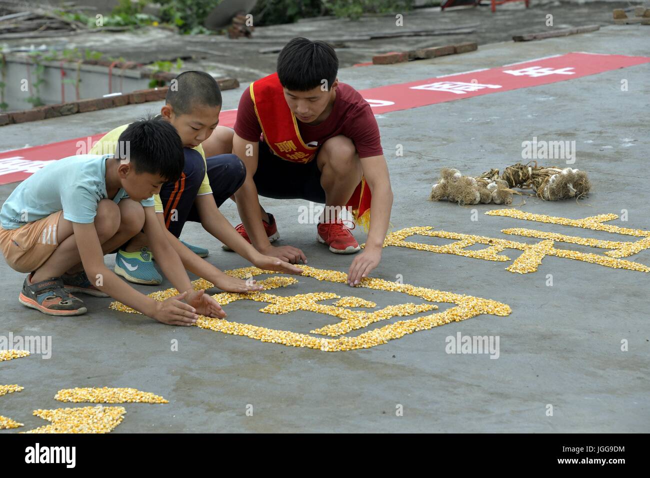 Liaocheng, Liaocheng, China. 6th July, 2017. Liaocheng, CHINA-July 6 2017: (EDITORIAL USE ONLY. CHINA OUT) Villagers and volunteers form eight Chinese characters saying 'Never Forget History, Reinvigorate the Country' with corns in Liaocheng, east China's Shandong Province, July 6th, 2017, marking the 80th anniversary of the July 7th 1937 Incident. July 7 marks the 80th anniversary of the Marco Polo Bridge Incident, which triggered the Chinese People's War of Resistance Against Japanese Aggression (1937-45) across the country. Credit: SIPA Asia/ZUMA Wire/Alamy Live News Stock Photo