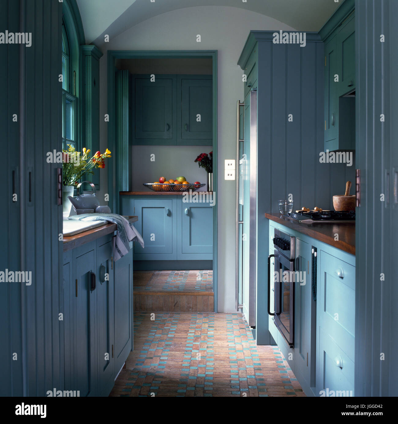 Blue traditional galley kitchen with Victorian tiled floor Stock Photo